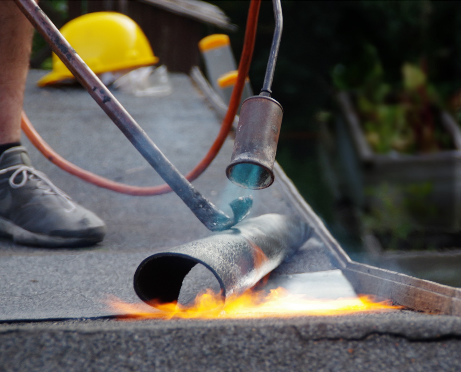 Roof house repair. Putting the roofing felt on the surface with a burner and fire.